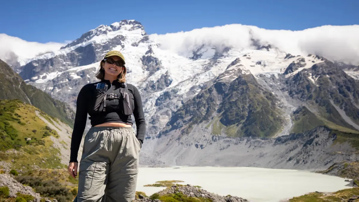 Backpacker op een wandelroute met besneeuwde bergen en een gletsjermeer